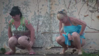 2 Russian women peeing behind shed
